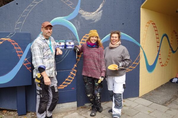 Konstnärerna Björn, Johanna och Therese tar en paus i arbetet med målningen.